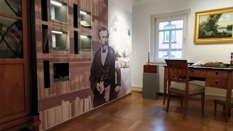 Blick in das nachempfundene Arbeitszimmer von Philipp Reis. Blick in das nachempfundene Arbeitszimmer von Philipp Reis im Philipp-Reis-Haus: Eine Wand mit Schaukästen und ein antiker Schreibtisch sind zu sehen