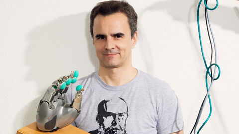 Jan Peters mit einem Roboterarm in der Hand