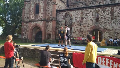 Schauspieler proben vor einer Burg.