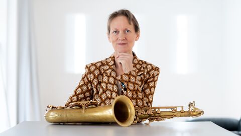 Corinna Danzer, Jazzpreisträgerin 2023 Die Jazzpreisträgerin Corinna Danzer sitzt an einem Tisch, vor ihr liegt ein Saxophon.
