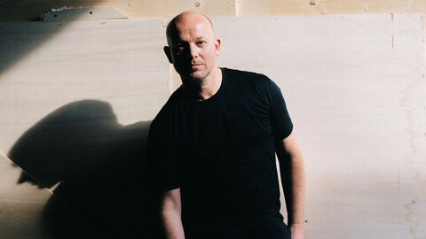 Ulrich Rasche erhielt 2023 den Hein-Heckroth-Bühnenbildpreis. Porträt von Ulrich Rasche, er steht vor einer Wand, ganz in Schwarz gekleidet