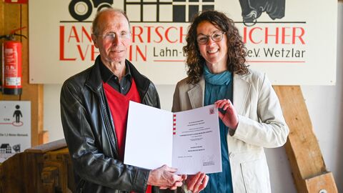 Wolfgang Hofmann vom Landwirtschaftlichen Museum nimmt die Urkunde "Museum des Monats" von Ministerin Angela Dorn entgegen.