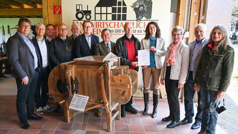 Ministerin Dorn mit den Mitgliedern des Landwirtschaftlichen Vereins Lahn-Dill Ministerin Dorn steht mit den Mitgliedern des Landwirtschaftlichen Vereins Lahn-Dill um eine historische Erntemaschine herum.