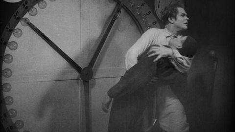 Szene aus dem Schwarzweiß-Film "Metropolis" Szene aus dem Schwarzweiß-Film "Metropolis": Zwei Männer stehen vor einer großen Uhr, der eine hält den anderen fest