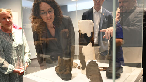 Das "Haus zum Löwen" zeigt auch das Leben der Hugenotten in Neu-Isenburg. Ministerin Dorn schaut sich in einer Vitrine Ausstellungsgegegenstände an.