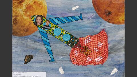 Eine Rakete im All, auf die Fotos einer Schülerin und eines Schülers geklebt wurden.