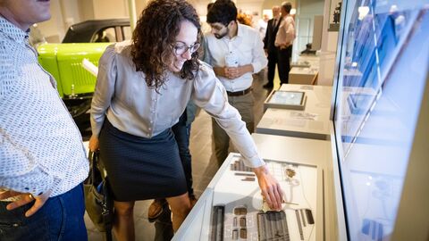 Ministerin Dorn schaut sich eine Vitrine mit dem Modell einer Produktionsanlage im Ober-Ramstädter Museum an.