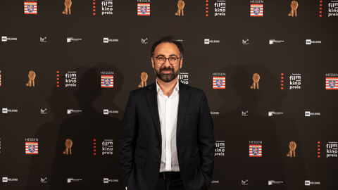Behrooz Karamizade, Träger des Newcomerpreises, vor der Fotowand Behrooz Karamizade, Träger des Newcomerpreises