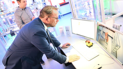 Das Fachgebiet Mess- und Regelungstechnik betreibt die Modellfabrik µPlant. In ihr wird die Produktion personalisierter Limonade mit Aromakugeln nachgestellt. Minister Gremmels schaut auf einen Bildschirm.