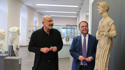 Die Kasseler Antikensammlung im Erd- und Untergeschoss von Schloss Wilhelmshöhe bietet einen Überblick über vergangene Kulturen im Mittelmeerraum, berichtet Museumsdirektor Prof. Dr. Martin Eberle. Minister Gremmels und Direktor Eberle schauen sich eine antike Statue an.
