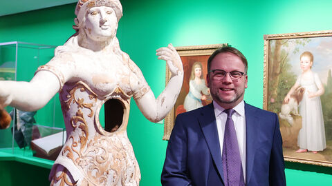 Kunst- und Kulturminister Timon Gremmels hat Schloss Wilhelmshöhe besucht, einen der Standorte der Hessen Kassel Heritage. Minister Gremmels neben einer Statue, die ein Loch im Bauch hat.