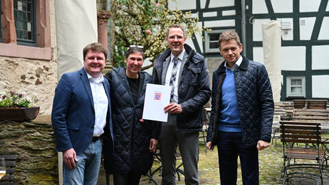 Staatssekretär Christoph Degen überreicht Sabine Kogge den Förderbescheid.