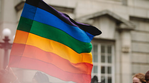 Zeichen setzen für Vielfalt und Akzeptanz. Menschen tragen eine Regenbogenflagge.