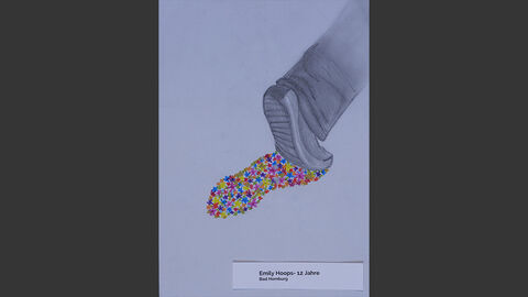 Ein grauer Fuß hinterlässt einen bunten Fußabdruck auf dem Asphalt.