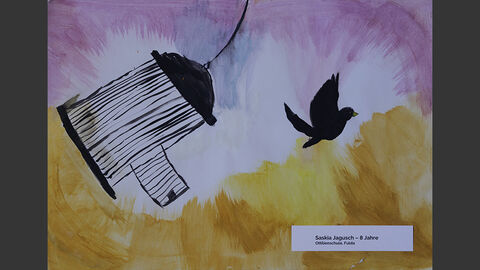 Ein schwarzer Vogel flattert aus einem geöffneten Käfig davon.