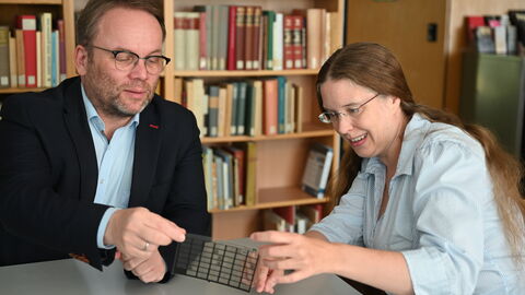 Impressionen vom Sommerreise-Besuch im Deutschen Musikgeschichtlichen Archiv Kassel Minister Gremmels sitzt mit einer Mitarbeiterin des Musikarchivs am Tisch und schaut Dias an.