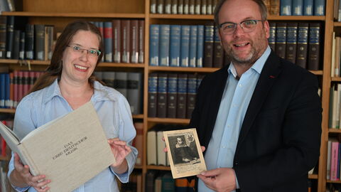 Impressionen vom Sommerreise-Besuch im Deutschen Musikgeschichtlichen Archiv Kassel Minister Gremmels und die Mitarbeiterin des Archivs halten historische Dokumente in die Kamera.