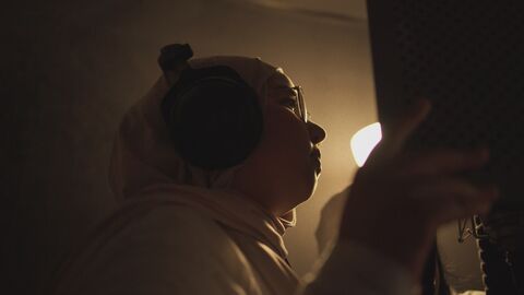 Szene aus "Sisterqueens" Szene aus "Sisterqueens": Ein Mädchen mit Kopftuch rappt am Mikro.