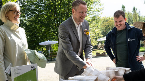 Fühlkästen laden ein zu testen, ob man Pflanzen und Früchte auch erkennen kann, wenn man sie nicht sieht. Staatssekretär Degen erfühlt Gegenstände in verdeckten Boxen.