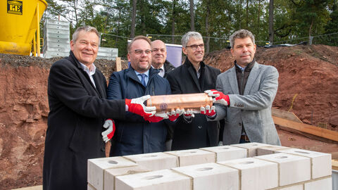 Grundsteinlegung für das  „Marburg Centre for Epidemic Preparedness“ (MCEP) Fünf Männer halten gemeinsam eine Zeitkapsel in der Hand.