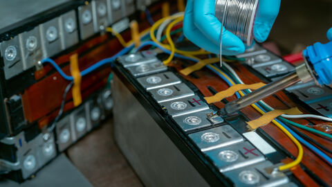 Techniker verwenden Lötkolben zum Löten von Metall und Draht des Lithium-Ionen-Akkus. 