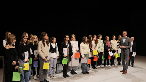 Staatssekretär Christoph Degen überreicht die Auszeichnung an die Preisträgerinnen und Preisträger von "Ohne Punkt und Komma".