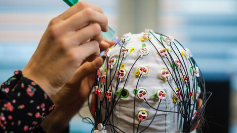 Eine Person trägt eine mit Kabeln verbundene Maske.