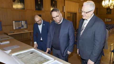 Minister Gremmels schaut sich historische Dokumente im Hessischen Landesarchiv an.