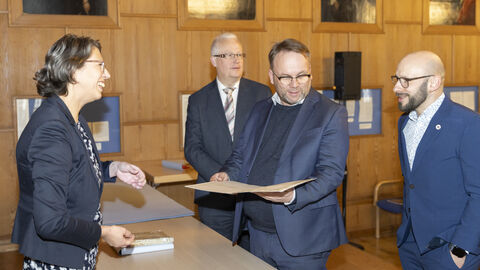 Minister Gremmels schaut sich historische Dokumente im Hessischen Landesarchiv an.