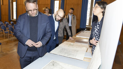 Minister Gremmels schaut sich historische Dokumente im Hessischen Landesarchiv an.