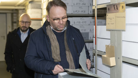 Minister Gremmels schaut sich historische Dokumente im Hessischen Landesarchiv an.