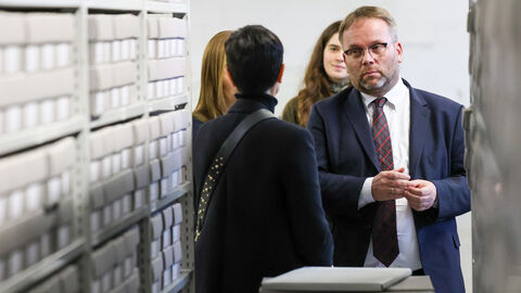 Minister Gremmels steht zwischen Archivschränken.