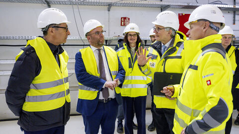 Minister Gremmels und Minister Özdemir stehen mit gelben Warnwesten auf der FAIR-Baustelle