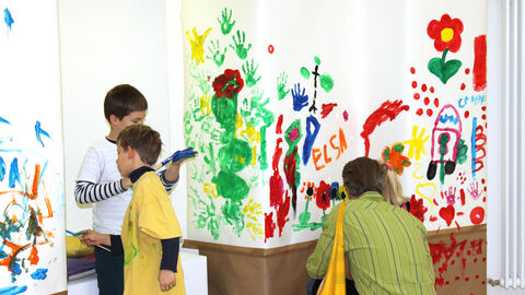 Kinder bemalen Säulen mit bunten Farben.