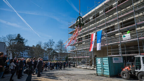 Der Richtbaum wird am Rohbau des Instituts für Lungengesundheit hochgezogen.
