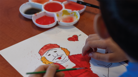 Ein Junge malt ein Bild.