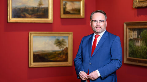 Staatsminister Timon Gremmels vor Gemälden im Museum Wiesbaden