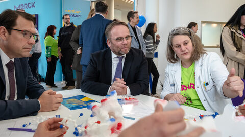 Wir müssen Lösungen finden, wie wir mit dem Klimawandel, der alternden Gesellschaft, internationalen Konflikten oder Volkskrankheiten umgehen“, sagte Timon Gremmels. Minister Gremmels am Tisch, umgeben von Forschenden.