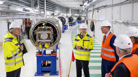 Staatssekretär Degen schaut sich den Beschleunigerring SIS100 an.