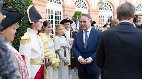 Impressionen von der Jubiläumsveranstaltung zu "Leben im Schloss". Minister begrüßt kostümierte Kinder.