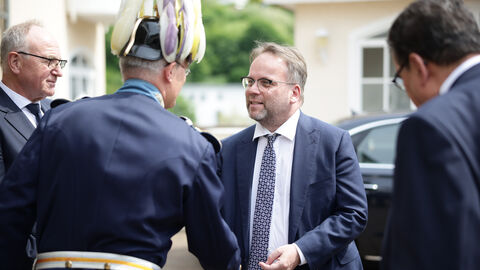 Impressionen von der Jubiläumsveranstaltung zu "Leben im Schloss". Minister schüttelt einem Mann die Hand.