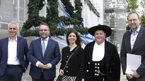 Minister Timon Gremmels mit vier weiteren Personen vor dem Rohbau.