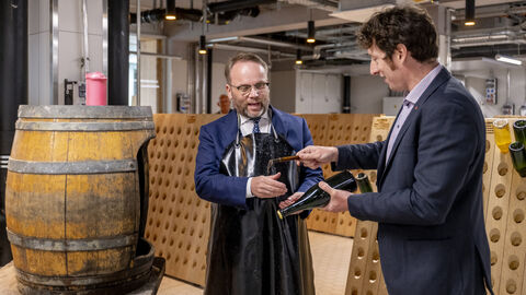 Minister Gremmels steht vor einem Fass.