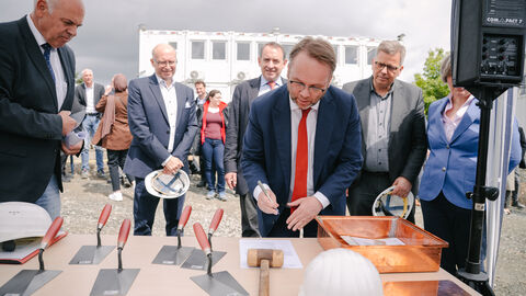 Minister Gremmels unterschreibt ein Dokument.