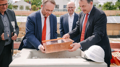 Minister Gremmels legt mit Minister Lorz eine Kiste in den Grundstein.