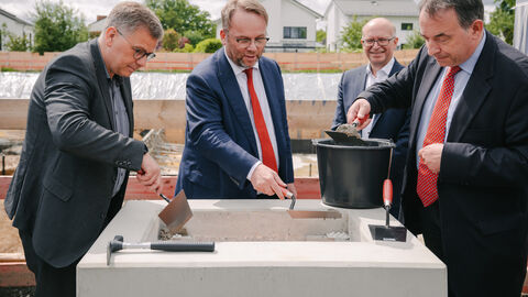 Minister Gremmels trägt Mörtel auf.