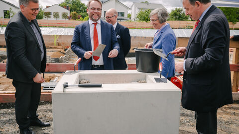 Minister Gremmels trägt Mörtel auf.