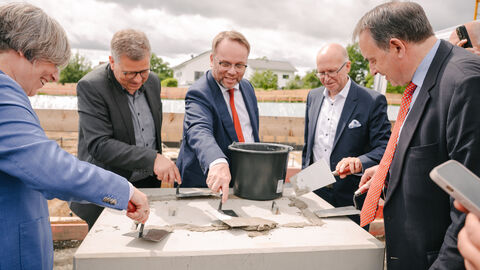 Minister Gremmels trägt Mörtel auf.