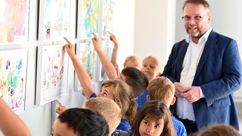 Kunst- und Kulturminister Timon Gremmels mit Kindern der Klasse 1 der Peter-Härtling-Schule Wetzlar, die einen Sonderpreis bekommen haben.