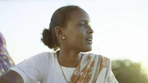 Szene aus "Cotton Queen": Eine schwarze, moderne Frau schaut zur Seite